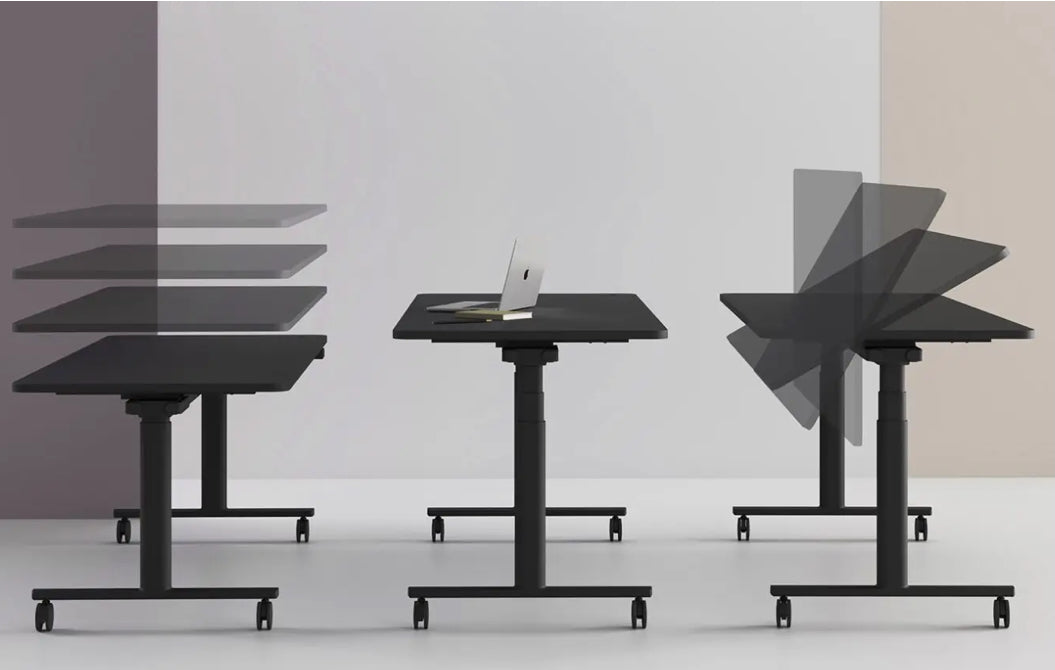 Set of adjustable height tables with a laptop on one of them against a plain background